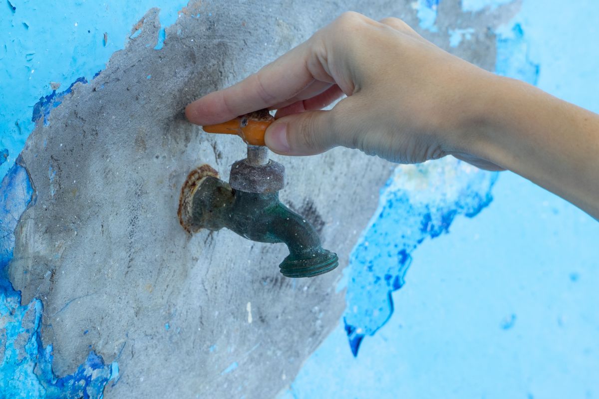 Technician thawing a frozen pipe with a heat gun