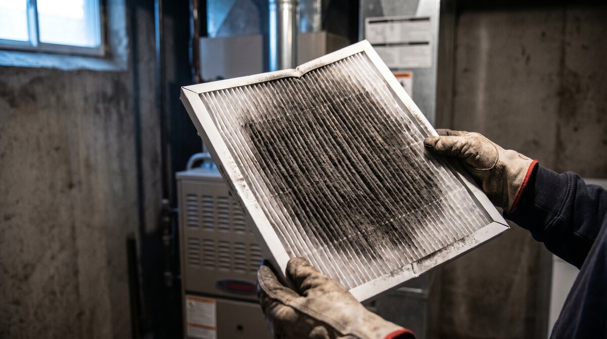 Heavily greyed furnace filter from a central Alberta home after wildfire smoke exposure