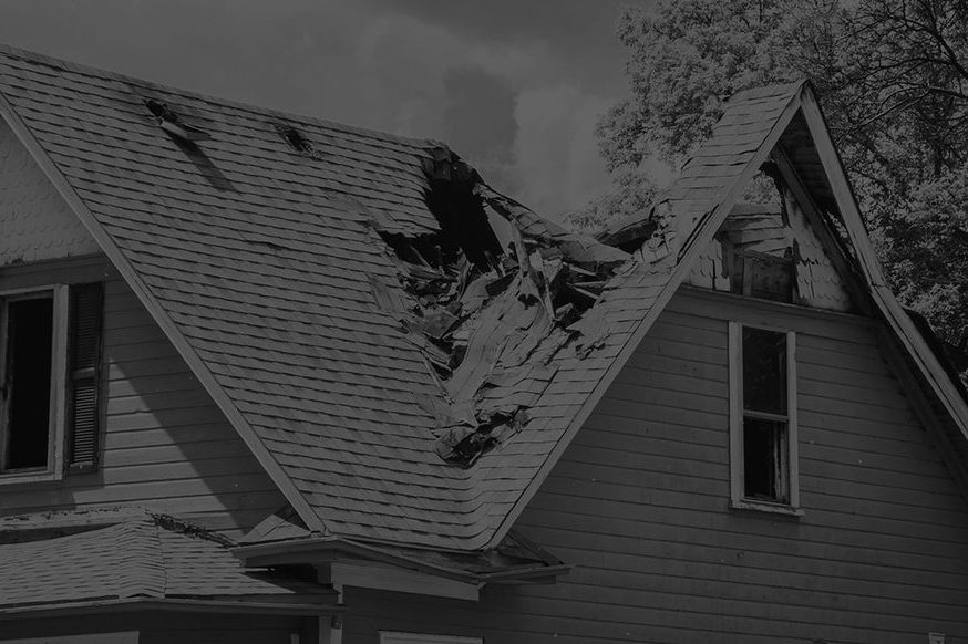 House roof with shingles and decking torn open by wind